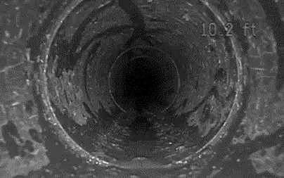 Vue de la caméra qui avance dans un drain : la paroi défile et le compteur de distance passe de 10 à 20 pieds.
